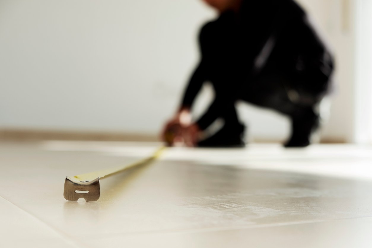 Man Measuring Tiled Floor